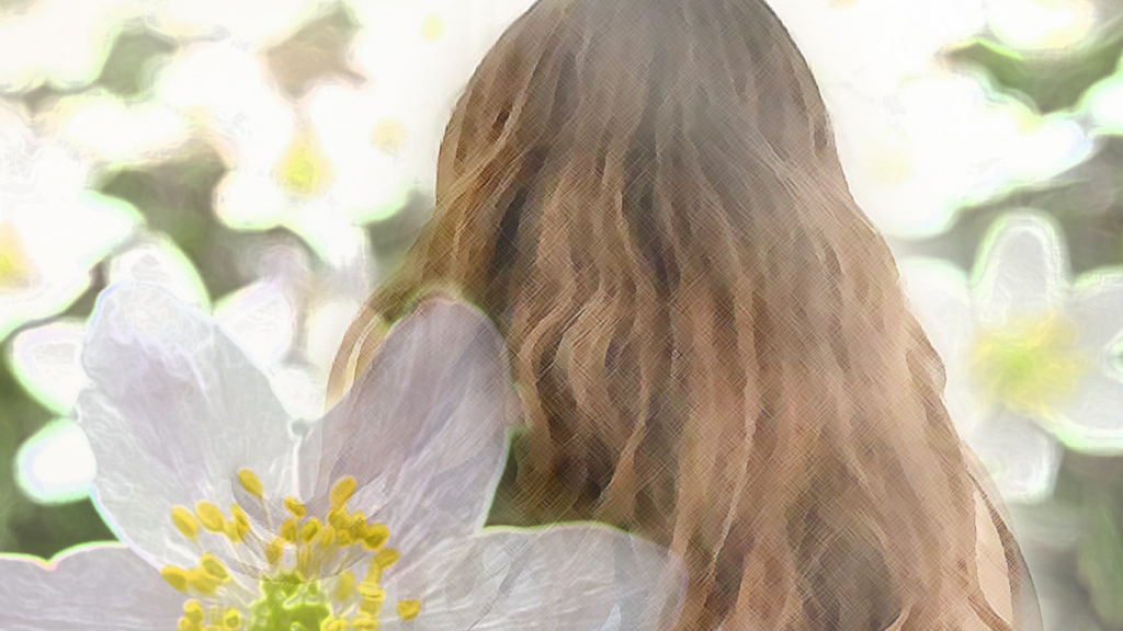 Långhårig flicka fotat vid vilda vita blommor